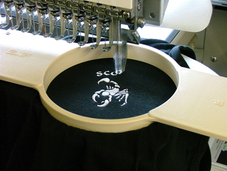 Scorpion logo being embroidered onto a black garment